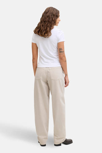 Ecru jeans special fit van JJXX, met wijde pijpen en achterzakken, gedragen met een wit T-shirt en zwarte schoenen.
