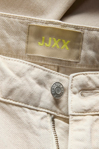 Ecru jeans special fit van JJXX, met merklabel en knoopsluiting in een close-up weergave.
