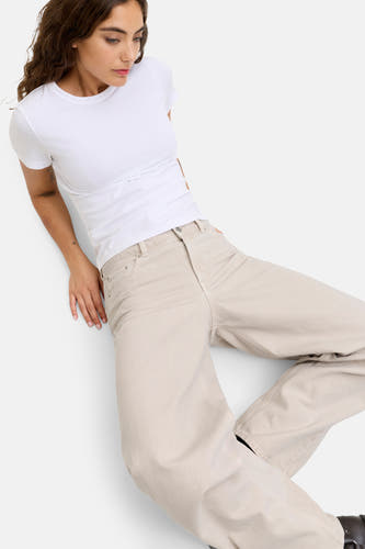Ecru jeans special fit van JJXX, met wijde pijpen en een vrouw met een wit t-shirt.
