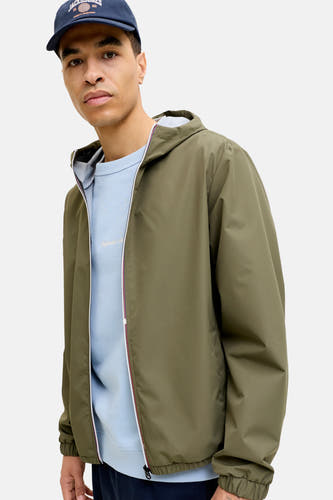 Manteau court vert de ORIGINALS BY JACK & JONES, avec capuchon et fermeture éclair, porté sur une chemise bleu clair avec un chapeau bleu marine.
