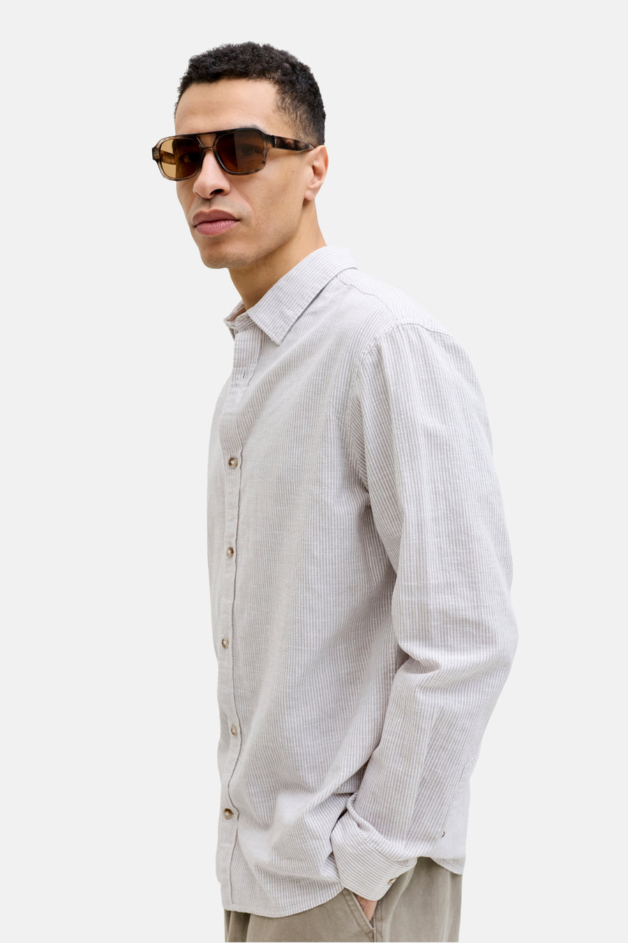 Beige gestreept overhemd van PREMIUM by JACK & JONES, met lange mouwen en knoopsluiting, gedragen met een kaki broek en bruine zonnebril.
