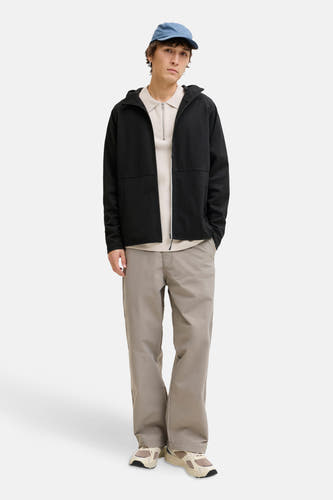Zwart gilet van CORE BY JACK & JONES, gedragen over een beige trui met rits en een blauwe pet.