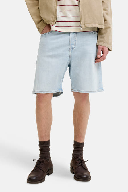 Jeansshort van lichtblauw denim van JACK & JONES JEANS INTELLIGENCE, gecombineerd met bruine schoenen en sokken.