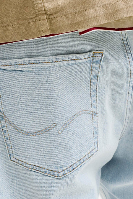 Jeansshort in lichtblauwe denim van JACK & JONES JEANS INTELLIGENCE, met achterzak en lichtgrijze broek.