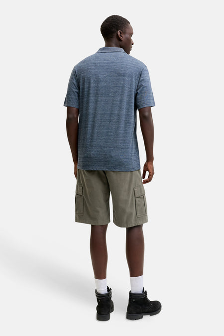 Kaki cargo short van JACK & JONES JEANS INTELLIGENCE, gedragen met blauw poloshirt en zwarte boots, rugaanzicht.