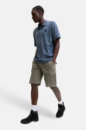 Short cargo JACK & JONES JEANS INTELLIGENCE avec poches cargo, porté avec un polo bleu et des bottes noires.
