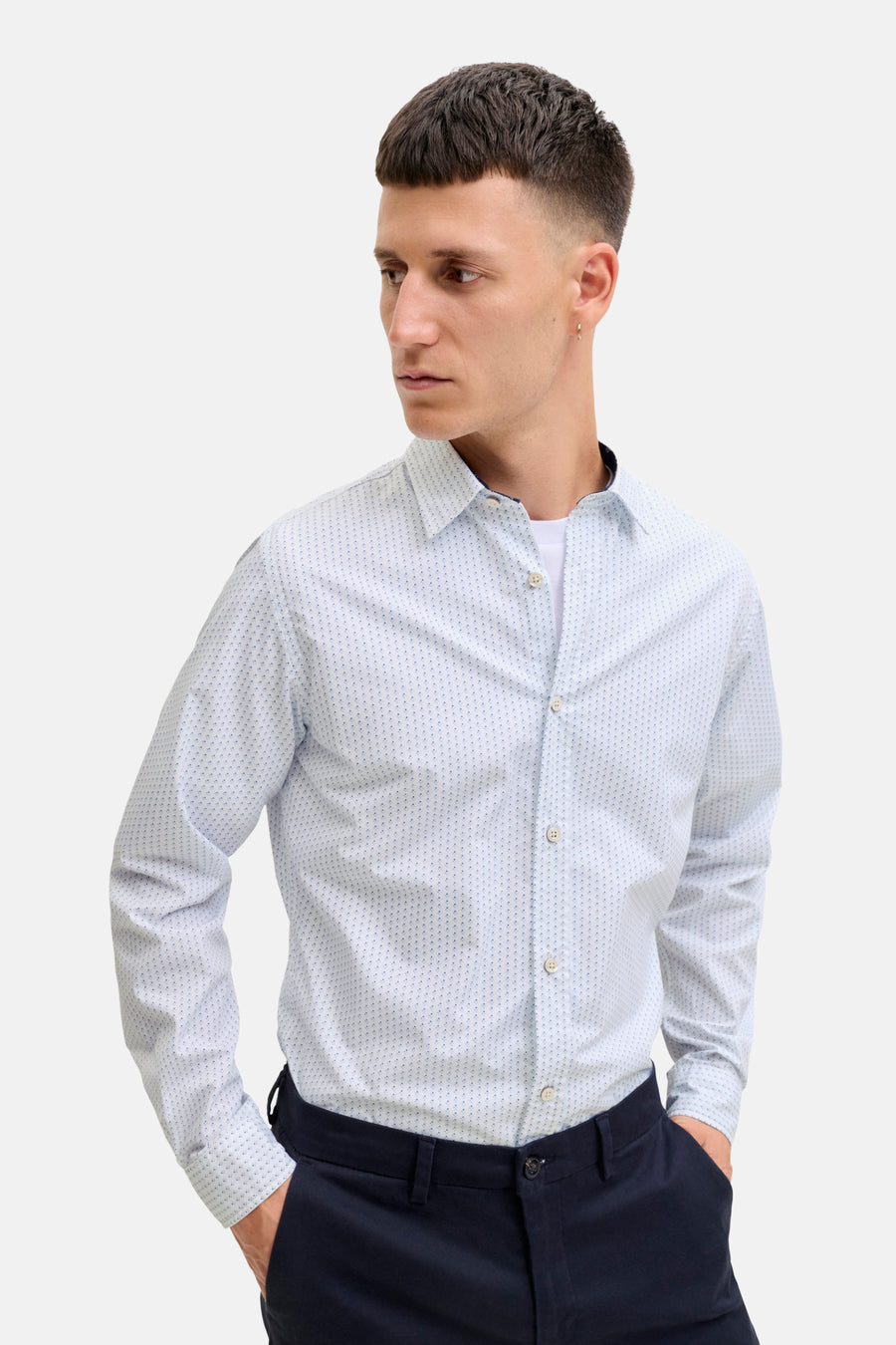 Man in lichtblauw overhemd met blauwe broek.