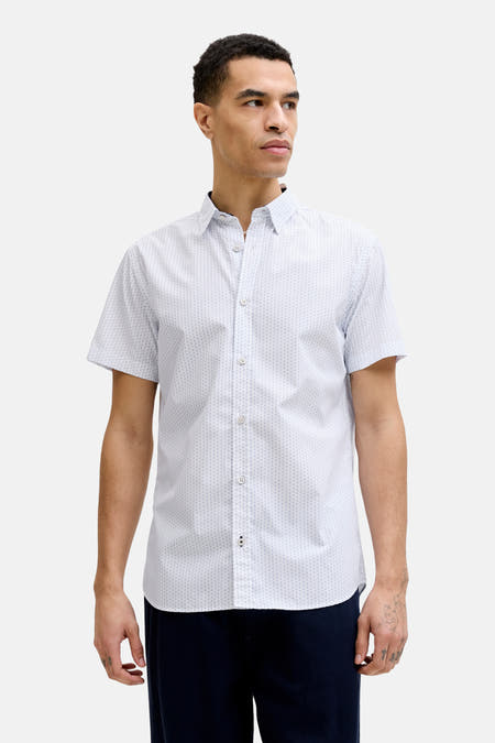 Chemise blanche à motif multicolore de PREMIUM by JACK & JONES, avec de petits carreaux bleus et bleu clair et un bouton à bordure rouge.