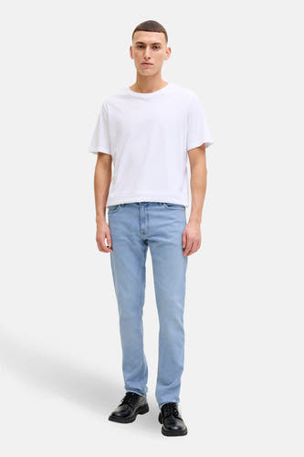 Slim fit lichtblauwe denim jeans van JACK & JONES JEANS INTELLIGENCE, gedragen met een wit T-shirt en zwarte schoenen.
