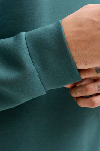 Blauwe sweater van CORE BY JACK & JONES, met lange mouwen en zichtbare hand met tatoeages.