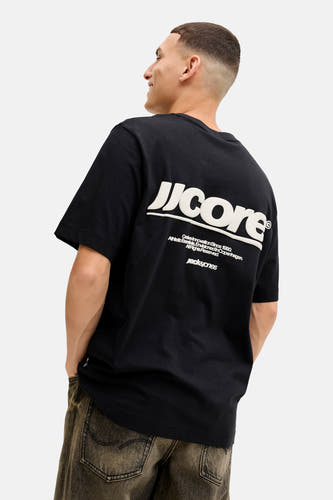 Zwart T-shirt met korte mouwen van CORE by JACK & JONES, met witte tekst op de achterkant en donkere broek.
