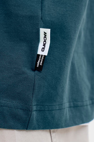 Blauw T-shirt met korte mouwen van CORE BY JACK & JONES, close-up van label met merknaam op effen stof.