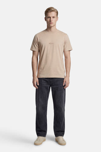 Beige T-shirt met korte mouwen van CORE BY JACK & JONES, gedragen met een donkere jeans en lichte schoenen.