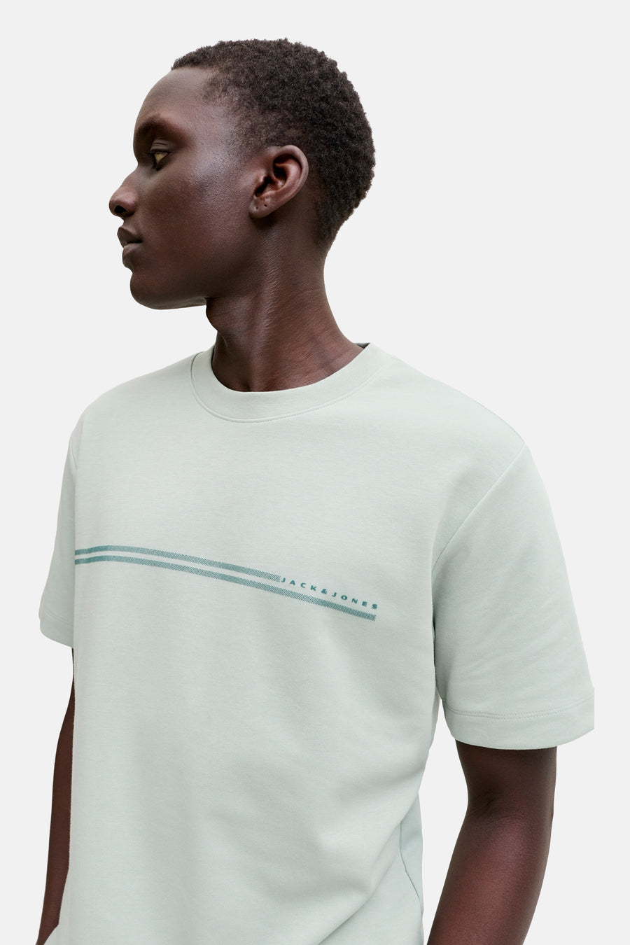 Lichtgroene korte mouw T-shirt van CORE BY JACK & JONES met horizontale streep en logo, zijprofiel van model