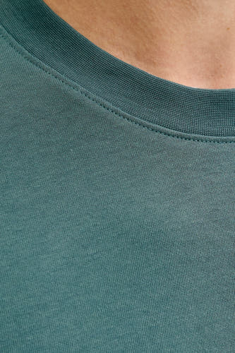 Groen T-shirt met korte mouwen van CORE BY JACK & JONES, close-up van de halslijn en stoftextuur.
