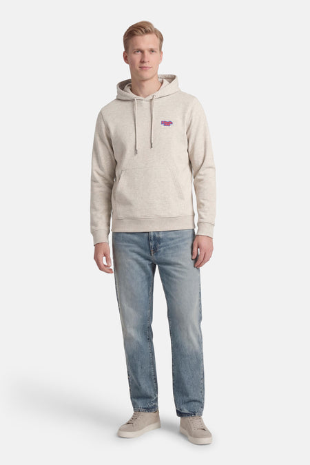 Grijze sweater met kap van CORE BY JACK & JONES, met een klein logo op de borst, gecombineerd met een jeans en sneakers.