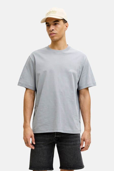 Blauw T-shirt met korte mouwen van ORIGINALS BY JACK & JONES, gedragen met een zwarte denim short en een beige pet.
