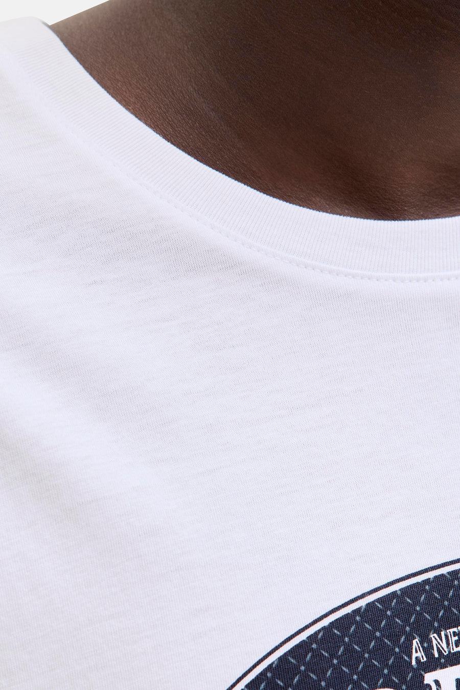 Wit T-shirt met korte mouwen van ORIGINALS BY JACK & JONES, close-up van de halslijn en een deel van een blauw motief.
