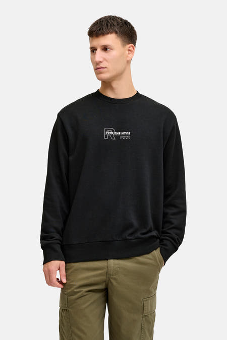 Zwarte sweater van JJREBEL, met een kleine witte print op de borst en geribde boorden.