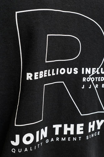 Zwarte sweater van JJREBEL, met grote witte letter 'R' en tekstuele details.