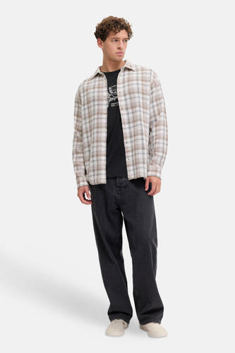 T-shirt noir à manches courtes de JJREBEL, avec un imprimé graphique et combiné avec une chemise à carreaux et un jean foncé.