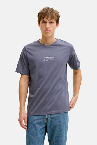 Blauw T-shirt met korte mouwen van JJREBEL, gedragen met een jeansbroek en effen achtergrond.

