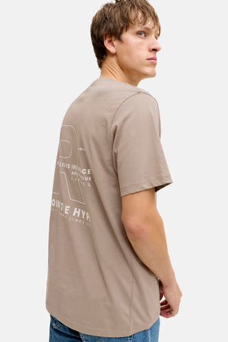 T-shirt marron à manches courtes de JJREBEL, avec imprimé blanc au dos et porté avec un jean bleu.