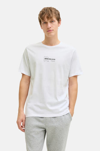 T-shirt blanc à manches courtes de JJREBEL, avec un petit imprimé texte noir sur la poitrine, combiné avec un jogging gris.