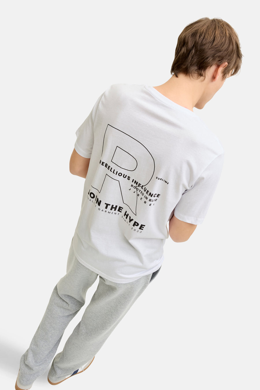 T-shirt blanc à manches courtes JJREBEL, avec imprimé noir au dos et pantalon de jogging gris.
