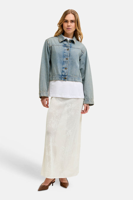 Lange witte rok van JJXX met gedetailleerd ajourpatroon, gestyled met een denim jasje.