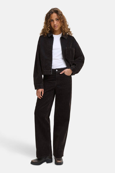 Bruine colored jeans van JJXX, gecombineerd met een wit t-shirt en een bruin jasje, staand gepresenteerd.
