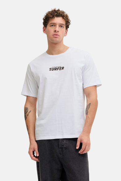 T-shirt blanc à manches courtes de JJREBEL, avec un imprimé texte sur la poitrine, combiné avec un jean foncé et des baskets claires.
