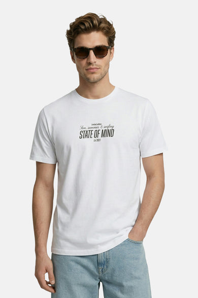 T-shirt blanc JJREBEL, à manches courtes et avec un petit imprimé texte, porté avec un short en jean et des sandales.