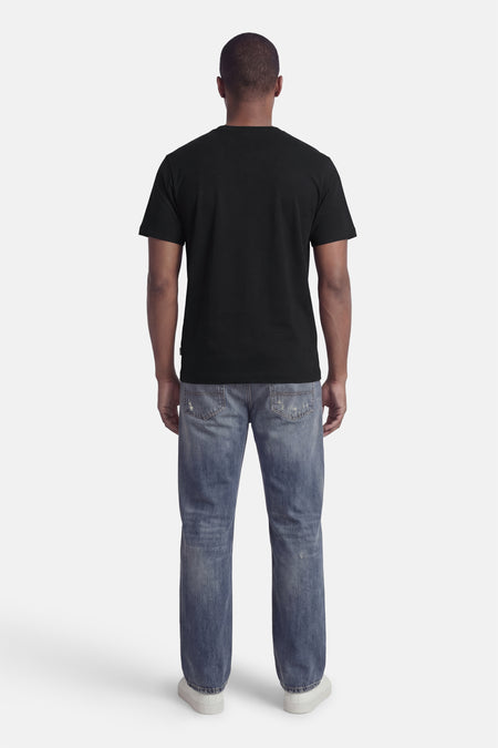 T-shirt noir à manches courtes de ORIGINALS BY JACK & JONES, vu de dos, avec jean et chaussures blanches.