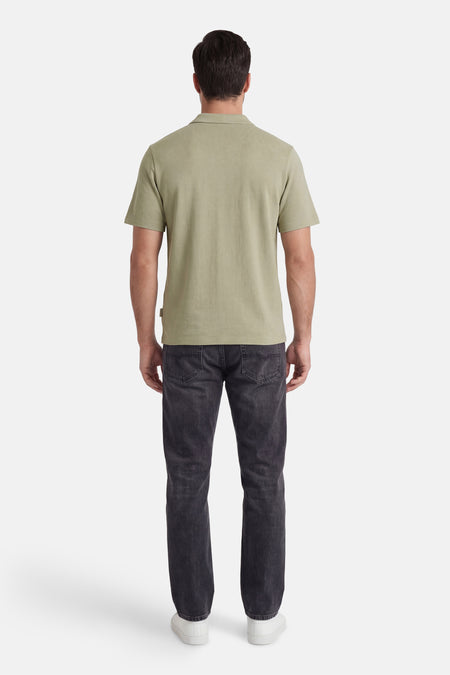 Polo verte de ORIGINALS BY JACK & JONES avec texture, vue de dos, portée avec un jean foncé et des baskets blanches.