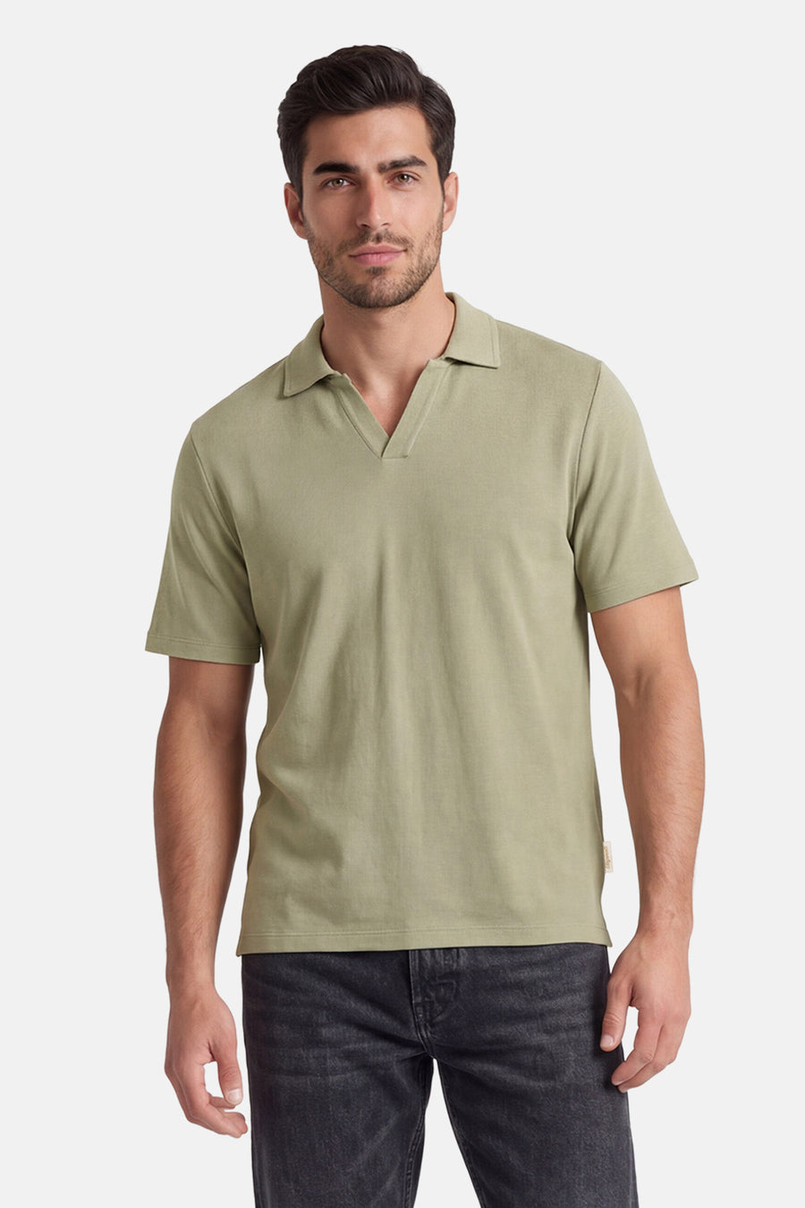 Polo verte ORIGINALS BY JACK & JONES de couleur verte avec col en V, portée par un homme en jean foncé.