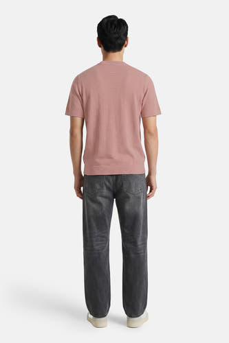 Roze ronde hals pull van PREMIUM by JACK & JONES, achterzijde weergegeven, fijn gebreid, korte mouwen, model draagt grijze jeans en witte sneakers