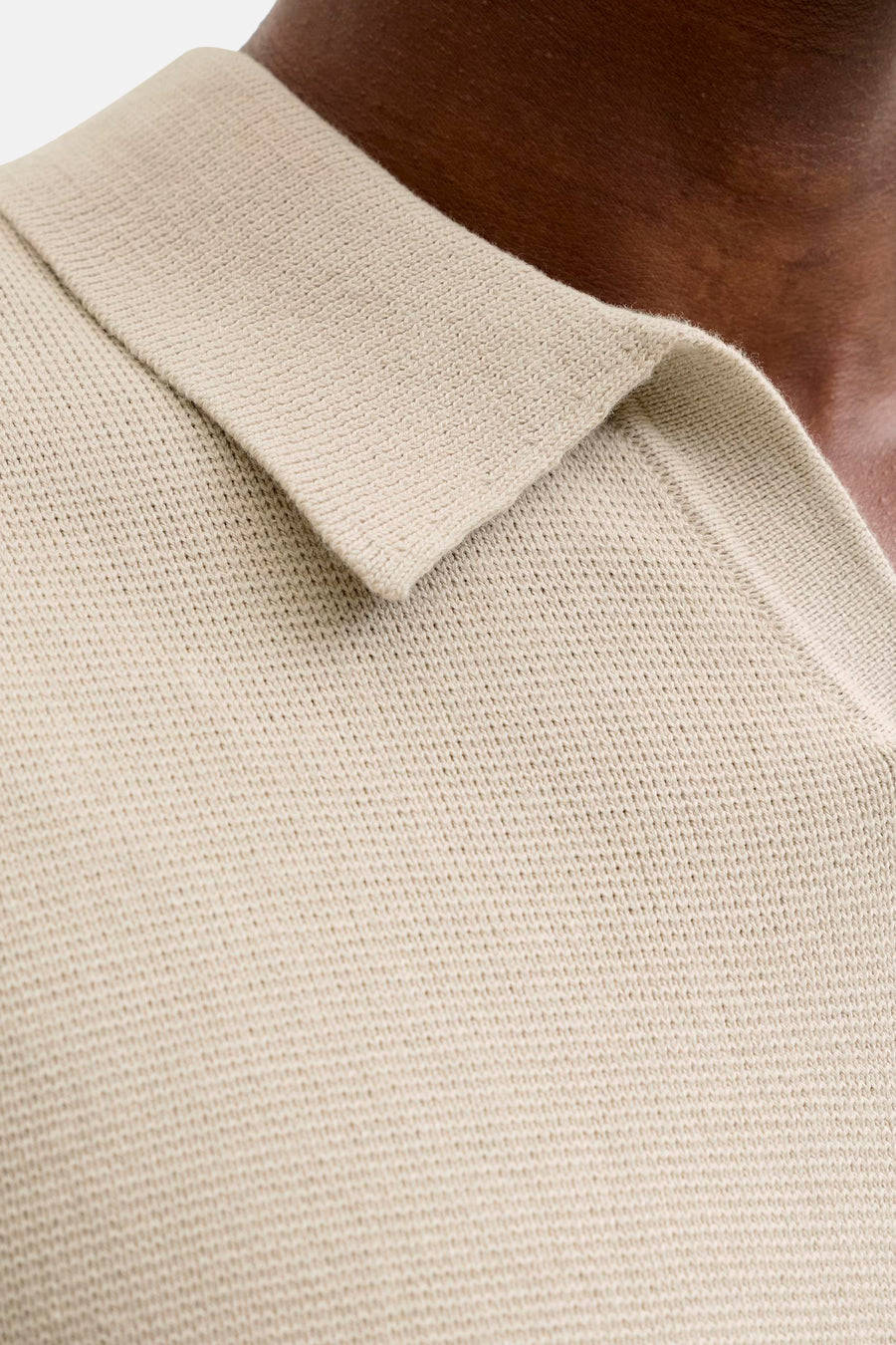 Beige polo met korte mouwen van PREMIUM by JACK & JONES, close-up van de kraag en gebreide textuur.