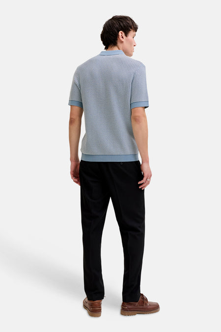 Polo bleu de PREMIUM by JACK & JONES, avec un motif finement tissé et un pantalon noir.