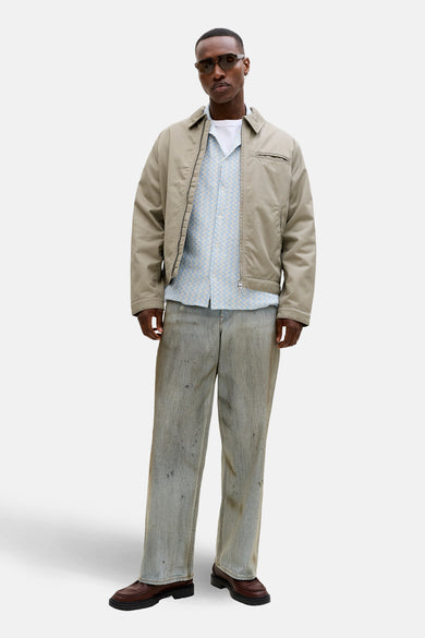 Blauw overhemd met korte mouwen van ORIGINALS BY JACK & JONES, met een subtiel patroon, gedragen met een beige jas en een witte T-shirt.
