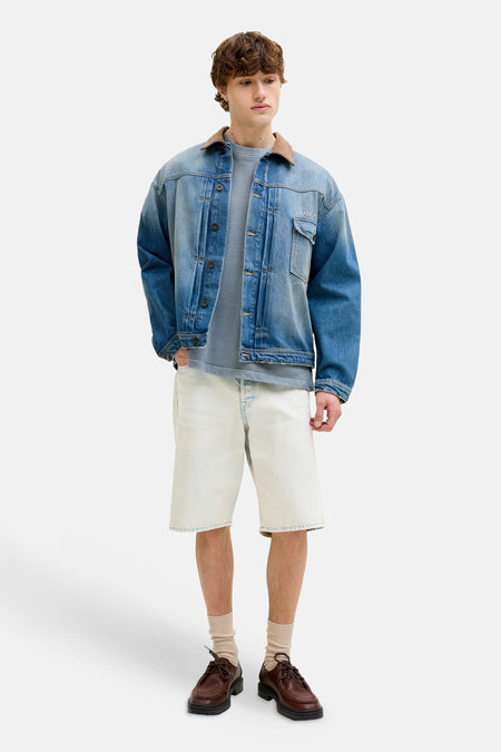 Lichtblauwe denim short van JACK & JONES JEANS INTELLIGENCE, gecombineerd met een spijkerjack en bruine schoenen.