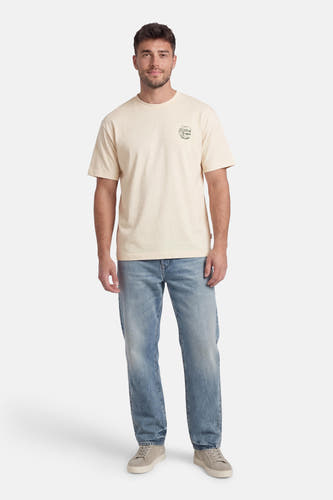Ecru T-shirt met korte mouwen van ORIGINALS by JACK & JONES, met een kleine print op de borst, gecombineerd met jeans en sneakers.