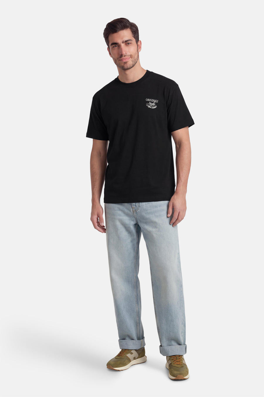 Zwart T-shirt met korte mouwen van ORIGINALS BY JACK & JONES, met een kleine witte print op de borst, gedragen met lichtblauwe jeans en groene sneakers.