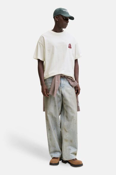 Wit T-shirt van ORIGINALS BY JACK & JONES, met een kleine rode print op de borst, gedragen met wijde jeans en een geruit overhemd om de taille.