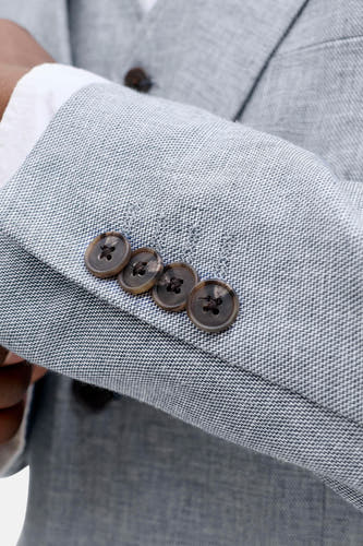 Lichtblauwe blazer van PREMIUM by JACK & JONES met een fijn visgraatpatroon en vier bruine knopen op de mouw.
