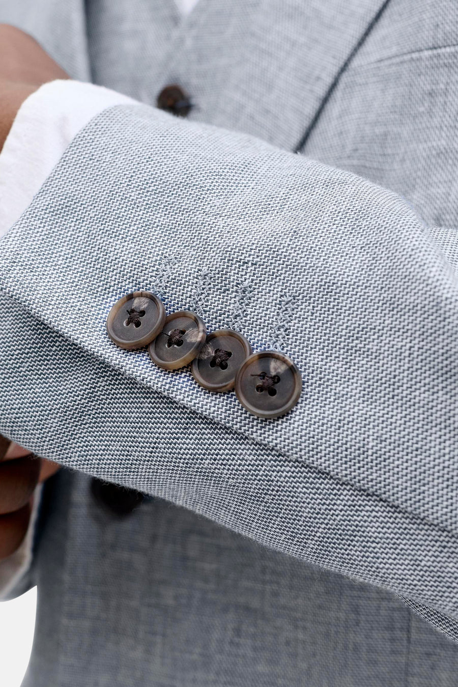 Lichtblauwe blazer van PREMIUM by JACK & JONES met een fijn visgraatpatroon en vier bruine knopen op de mouw.