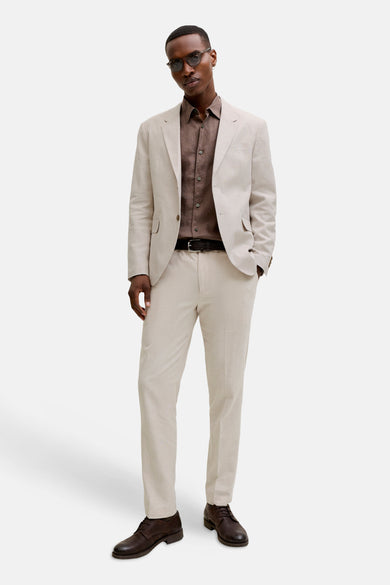 Ecru kostuumbroek van PREMIUM by JACK & JONES, gecombineerd met een bruin overhemd, zwarte riem en bruine leren schoenen.
