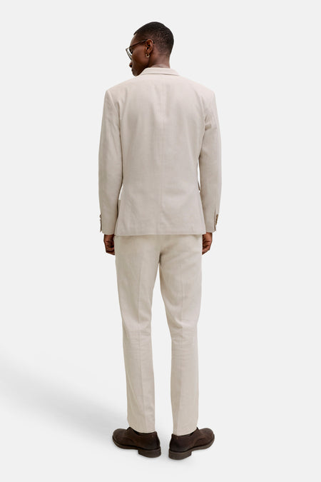 Pantalon de costume écru de PREMIUM by JACK & JONES, vu de dos, avec veste assortie et chaussures marron foncé.