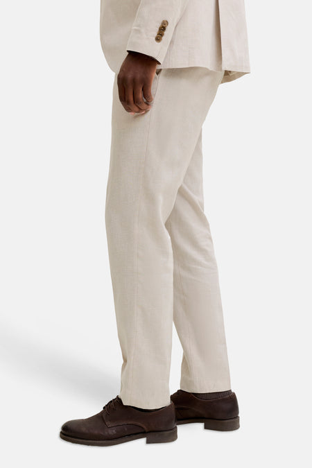 Pantalon de costume écru de PREMIUM by JACK & JONES, avec des chaussures en cuir marron et des chaussettes marron, en vue de côté.