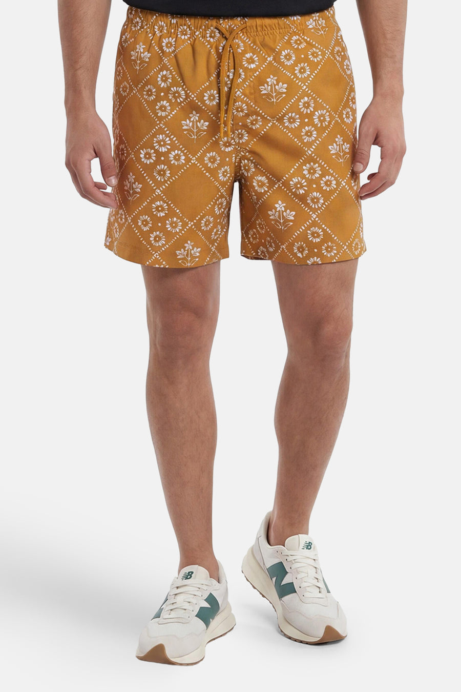 Gele zwemshort van PREMIUM by JACK & JONES met wit bloemen- en ruitpatroon en trekkoord, gedragen door een man.